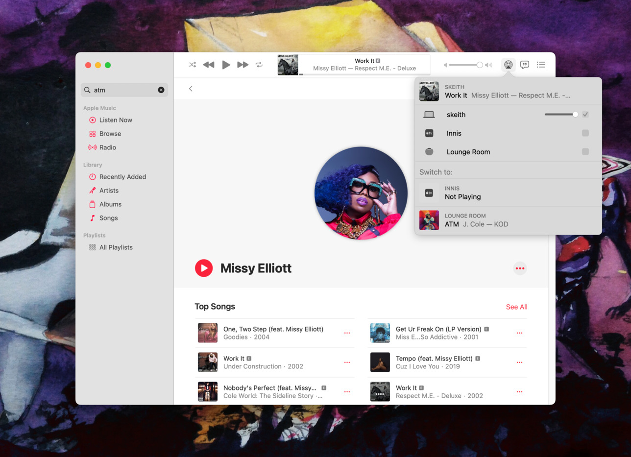A screenshot of the Apple Music client open to the artist page for Missy Elliot. A share icon in the top right of the navigation bar has been selected, with multiple Apple devices visible such as a laptop, Apple TV and Homepod. The song Work It by Missy Elliot has just started playing. Visible in the share switcher is the ability to switch to the "Lounge Room", in this case the Homepod, where ATM by J. Cole was previously playing.