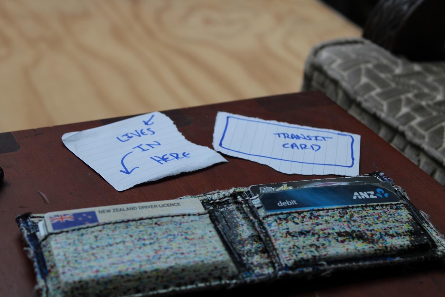 A close up photo of a table with my wallet folded open on it. A piece of paper represents my transit card as I no longer had it at the time of writing this post.
