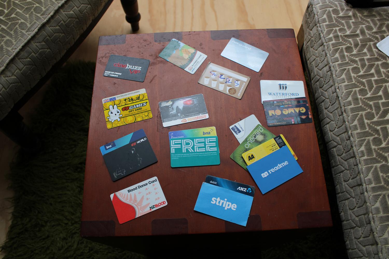 An aerial photo of a table with numerous cards scattered around. There are different types from loyalty cards to business cards, as described below.